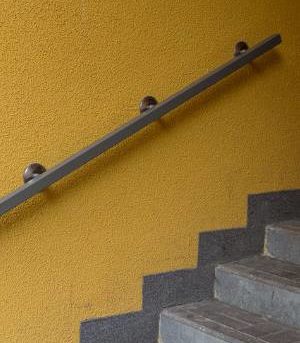Metal Railing on Yellow Wall Metal Railing Installed by BILD in Milwaukee