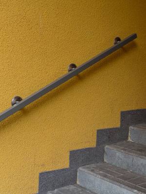 Metal Railing on Yellow Wall Metal Railing Installed by BILD in Milwaukee